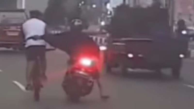 Tangkapan layar video aksi jambret pemotor terhadap pesepeda di Palembang.