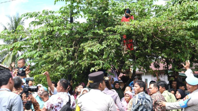 Seorang Perempuan Naik Pohon Saat Kunker Presiden Jokowi di Bengkulu Utara