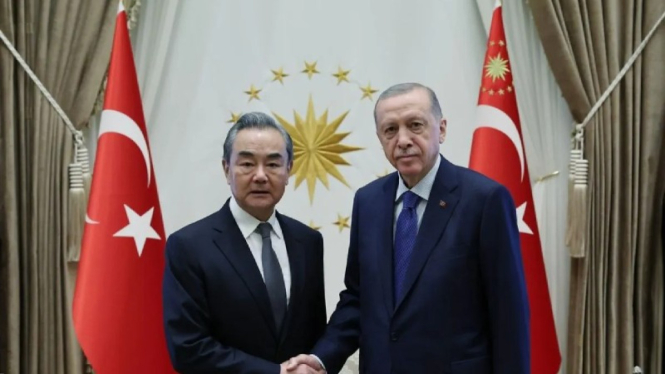 Presiden Turki Recep Tayyip Erdogan (kanan) berjabat tangan dengan Menlu China, Wang Yi (kiri).