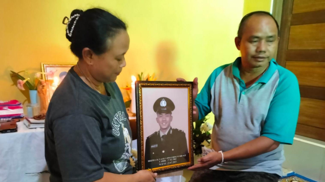 Orangtua Bripda Ignatius Dwi Frisco Sirage menunjukkan foto korban semasa hidup