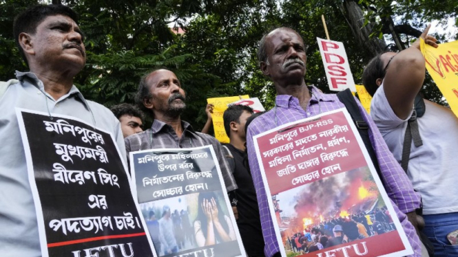 Para aktivis India melakukan unjuk rasa menentang kekerasan antaretnis.