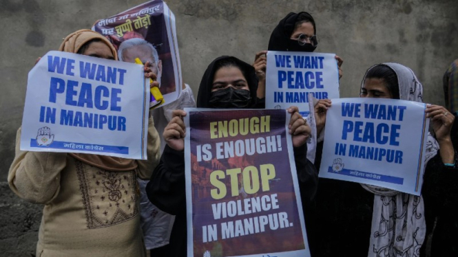 Para aktivis India melakukan unjuk rasa menentang kekerasan antaretnis.