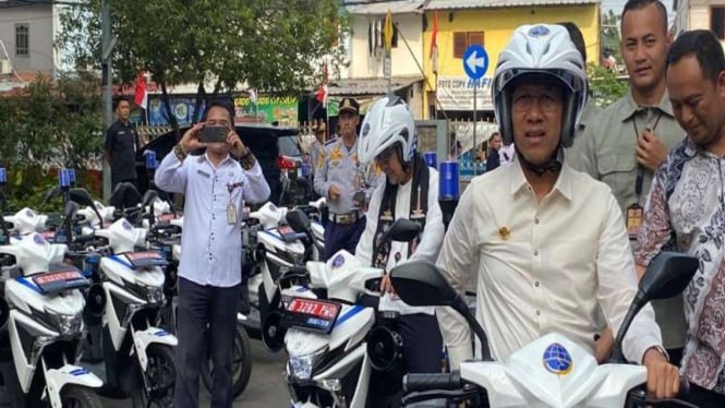 Pj Gubernur DKI Heru Budi menyerahkan motor listrik kepada petugas Dishub.