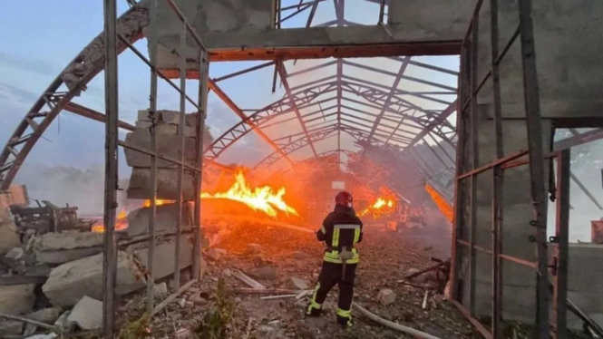 Seorang petugas pemadam kebakaran bekerja di lokasi yang terkena serangan pesawat tak berawak (drone) Rusia.