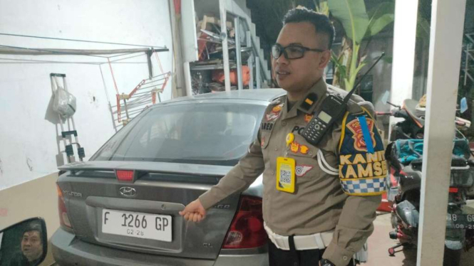 Polisi mengecek nomor polisi mobil sedan yang viral mengemudi sempoyongan