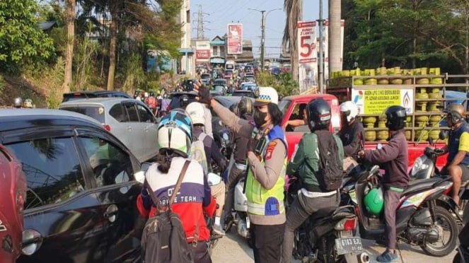 Petugas Mengataur Lalu Lintas Yang Macet Akiat Kabel Menjuntai di Depok.