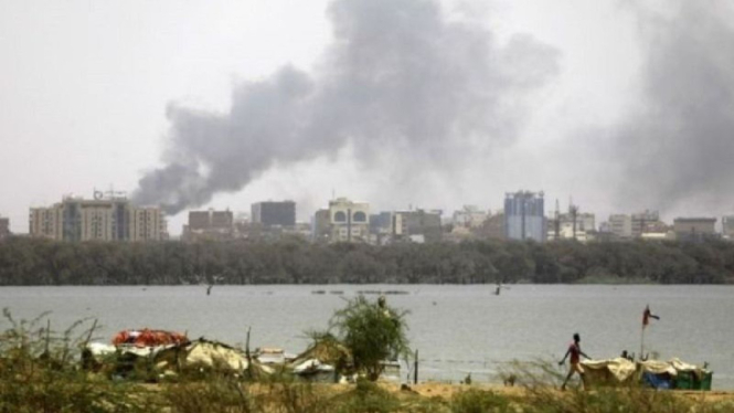 Asap mengepul di udara dari sebuah gedung yang terbakar akibat bentrok antara angkatan bersenjata pemerintah Sudan dan kelompok paramiliter RSF di Khartoum, Sudan. 