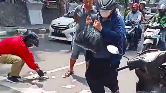 Uang pecahan Rp 100 ribuan berhamburan di jalan protokol Medan.