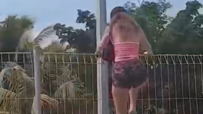 Uma mulher estrangeira decidiu escalar o muro do BRC no Aeroporto I Gusti Ngurah Rai, em Bali.