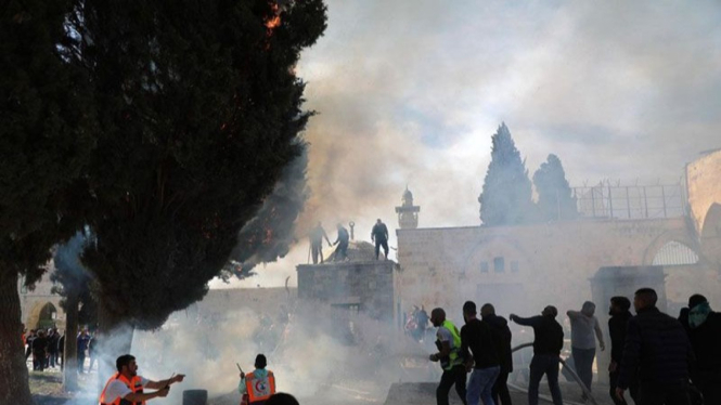 Para petugas memadamkan kobaran api saat bentrokan antara pasukan keamanan Israel dan warga Palestina di kompleks Masjid Al Aqsa di Yerusalem Timur.