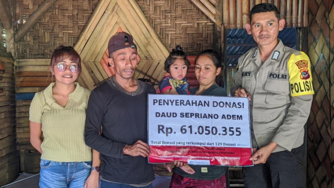 Bripka Heri Tena menyerahkan batuan ke warga di Manggarai Timur, NTT 