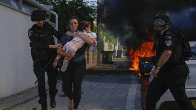 Polisi mengevakuasi seorang wanita bersama anaknya di Gaza.
