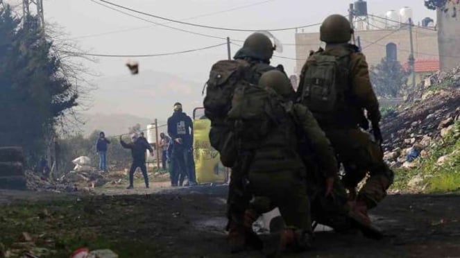 ARCHIVO - Manifestantes palestinos junto a soldados israelíes después de una protesta contra la expansión de los asentamientos judíos en la aldea de Kufr Qadum, cerca de la ciudad de Nablus, en Cisjordania, el viernes 4 de febrero de 2022.