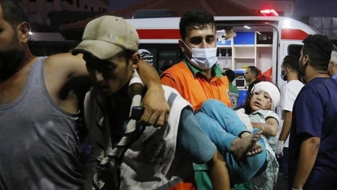Petugas medis membawa korban serangan Israel ke sebuah rumah sakit di Gaza. 