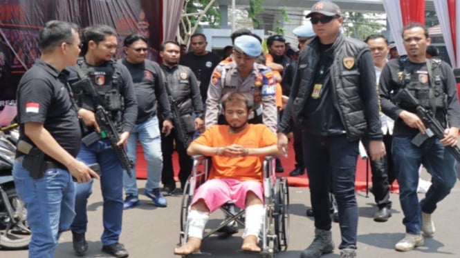 Pelaku T di kursi roda yang didorong polisi,