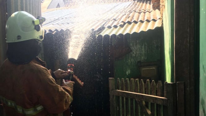 Petugas Damkar memadamkan api di kadang ayam milik lansia di Mojokerto