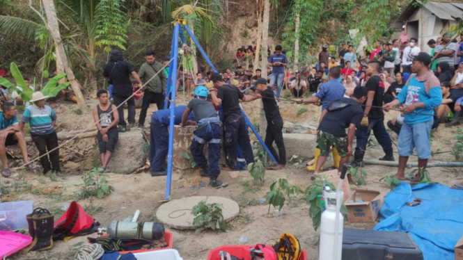 Warga dan petugas saat mengevakuasi dua korban tewas di dalam sumur di Tuban