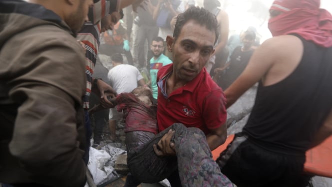 Seorang pria Palestina membawa mayat seorang anak yang tewas akibat serangan Israel. (ilustrasi)