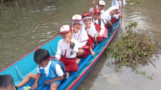 Siswa SD dan TK sekolah naik perahu lewati sungai setiap hari.