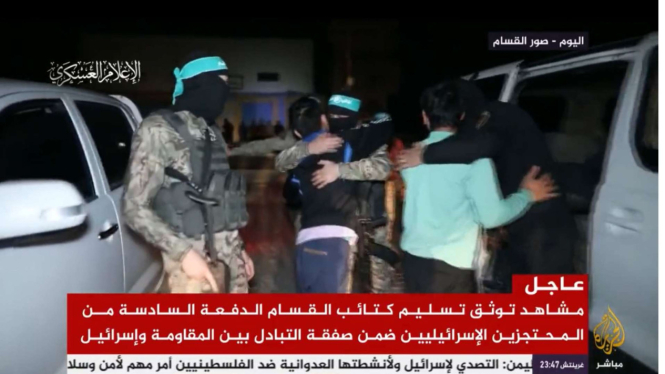 Tentara Hamas memeluk sandera yang dibebaskan