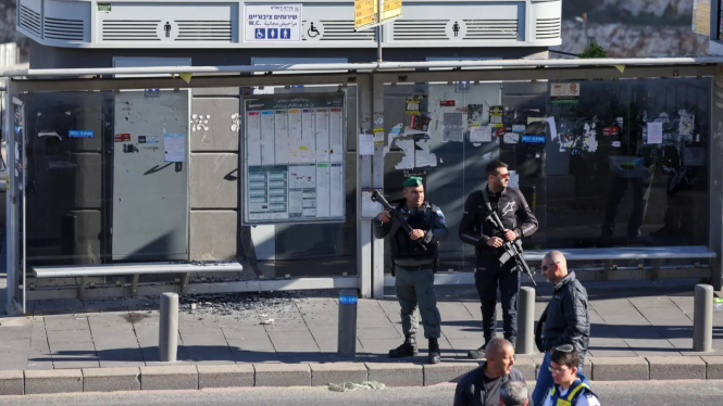Polisi Israel berjaga-jaga di sekitar lokasi penembakan massal di sebuah halte bus di pintu masuk Yerusalem hari Kamis, 30 November 2023.