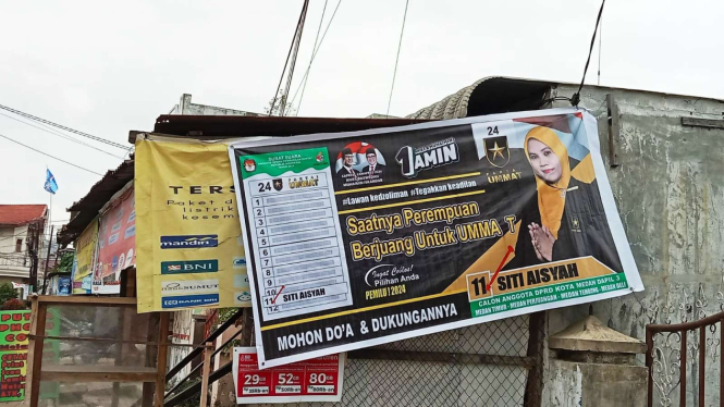 Spanduk Caleg Partai Ummat Siti Aisyah menutupi toko milik warga