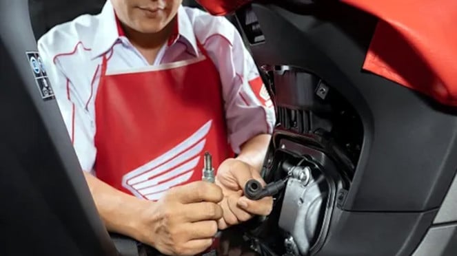 Mechanic checking motorcycle spark plugs