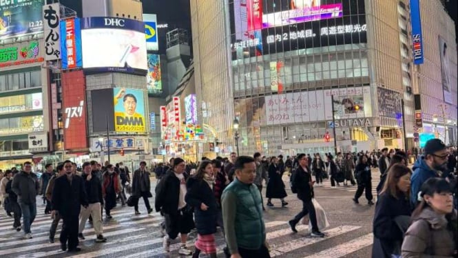 Suasana Shibuya Scramble Crossing, Tokyo, Jepang, di malam hari.