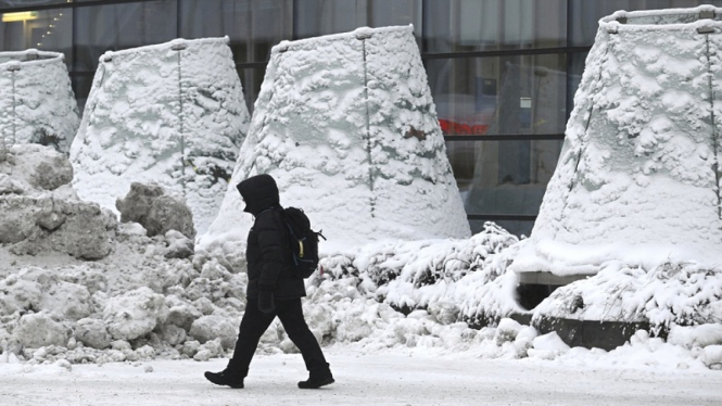 Pria berjalan di tenga cuaca salju ekstrem melanda Helsinki, Finlandia (3/1)