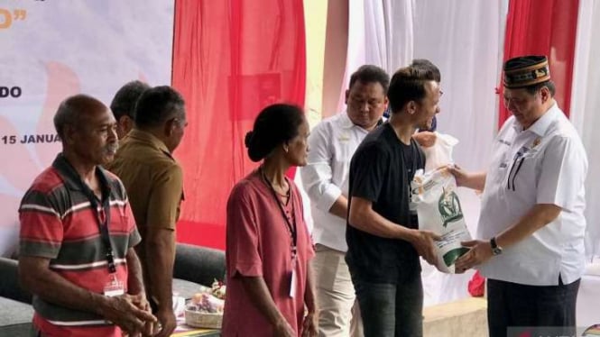 Menteri Koordinator Bidang Perekonomian Airlangga Hartarto (kanan) menyerahkan bantuan pangan berupa beras 10 kilogram kepada warga di Gudang Bulog Batu Cermin, Manggarai Barat, Nusa Tenggara Timur, Senin, 15 Januari 2024.
