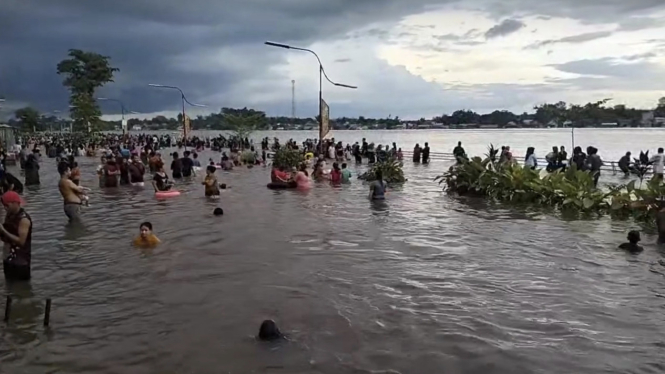 Banjir yang terjadi dimanfaatkan warga dengan sebagai rekreasi di Kabupaten Sintang, Kalimantan Barat. 