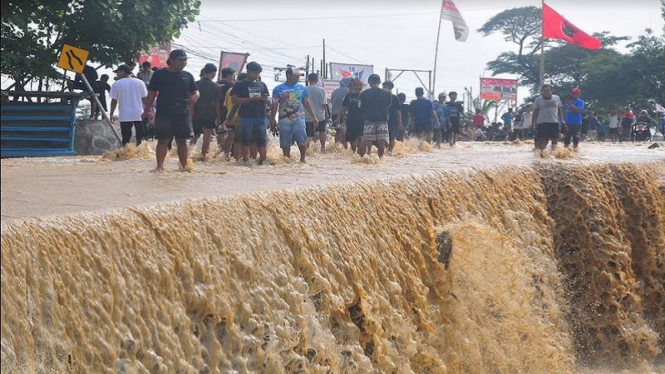 Warga saat menyaksikan jalan Gubug, Grobogan ambrol akibat tergerus banjir