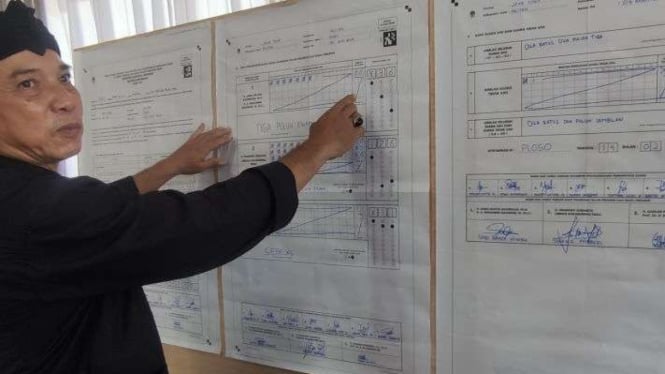 Ketua KPPS TPS 16 Fadjar Setiyo Asmoro membacakan hasil rekapitulasi pilpres di 
