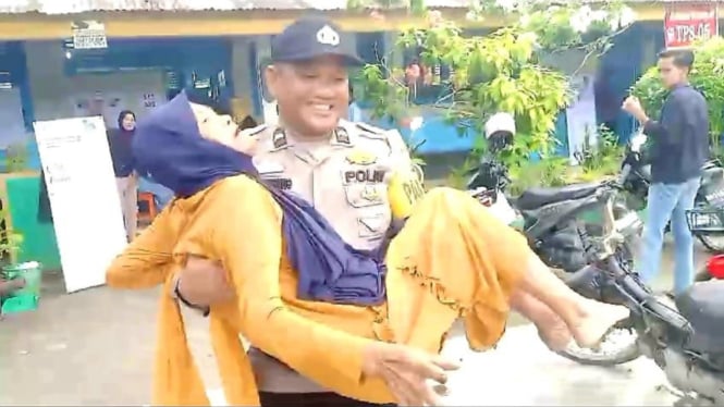 Anggota Ditlantas Polda Riau menggendong nenek ke TPS