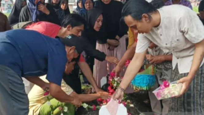 Keluarga menaburkan bunga di makam Joko Budiono, Ketua KPPS di Surabaya, yang meninggal dunia pada 16 Februari 2024.