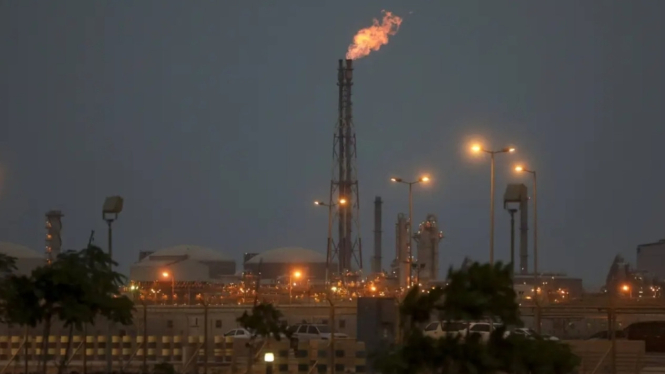 Lampu menerangi pabrik pengolahan fosfat saat api menyala dari cerobong asap di Arab Saudi (Doc: MEMO)