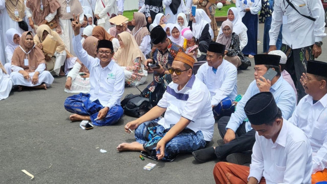 Orang kaya Madura Haji Her bersama pegawainya dan warga Pamekasan
