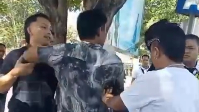 Polisi mengamankan pengemudi taksi liar yang  adu mulut dengan petugas avsec bandara Ngurah Rai Bali