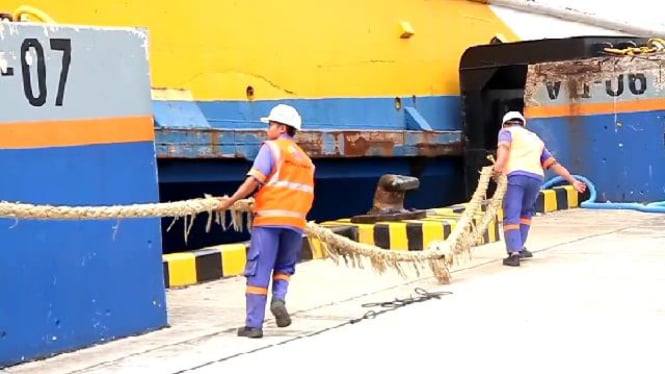 Petugas penarik tali tambang kapal di Dermaga Pelabuhan Bakauheni, Lampung.