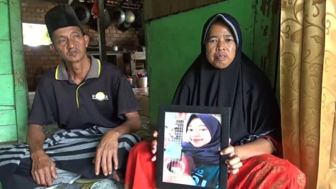 Kedua orang tua Nasifa saat memperlihatkan foto korban semasa masih hidup