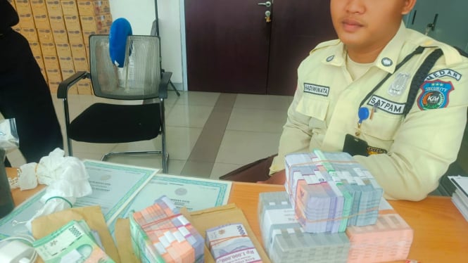 Petugas security KAI Bandara Medan saat mengembalikan uang ditemukan kepada pemiliknya.(istimewa/VIVA)