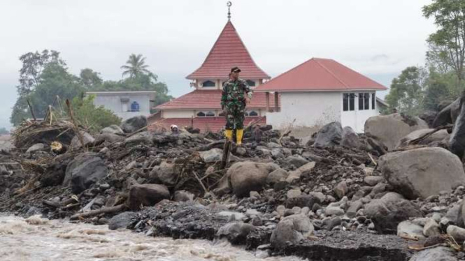 Seorang personel TNI memantau arus Sungai Batang Katiak setelah banjir lahar dingin dari Gunung Marapi di Kabupaten Agam, Sumatra Barat.