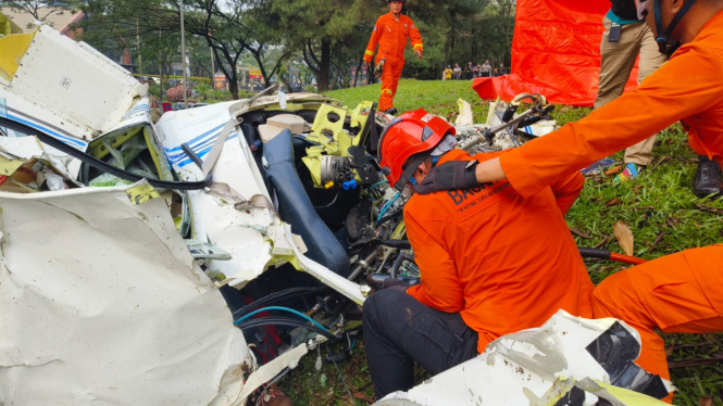 Petugas gabungan melakukan evakuasi pada korban pesawat jatuh di Lapangan Sunburst, Kecamatan Serpong, Kota Tangerang Selatan, Banten, Minggu siang, 19 Mei 2024.
