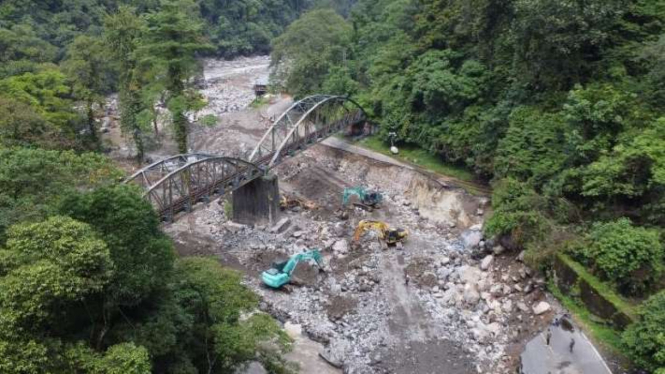 Potret udara sejumlah alat berat membersihkan dan mengerjakan jalan nasional yang rusak parah akibat diterjang luapan air Sungai Batang Anai di Kabupaten Tanah Datar, Sumatra Barat.