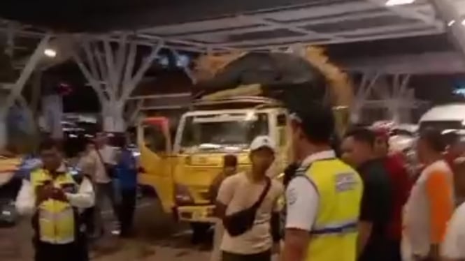 Bule mengandarai mobil truk bermuatan gabah menerobos palang pintu tol masuk ke terminal keberangkatan internasional Bandara I Gusti Ngurah Rai