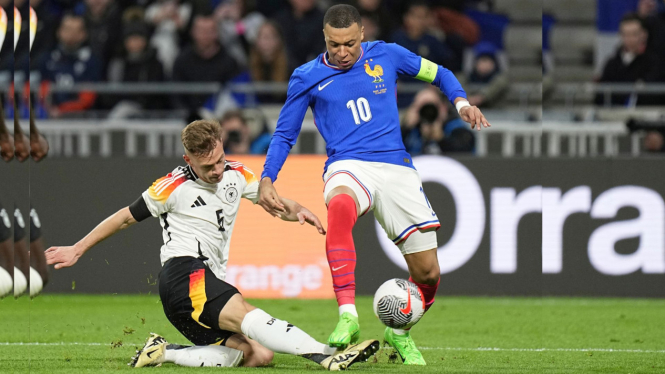 Joshua Kimmich dari Jerman berebut bola dengan Kylian Mbappe dari Prancis