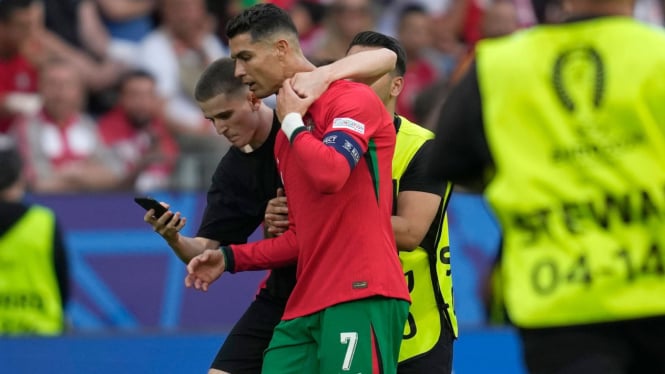 Pitch invader mencoba berfoto selfie dengan pemain Portugal Cristiano Ronaldo