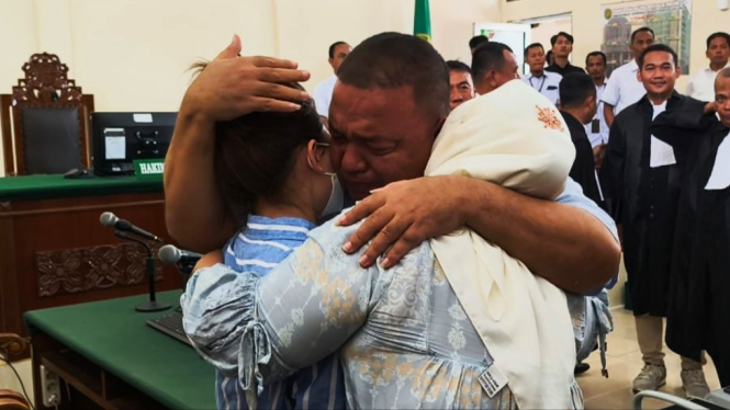 Terdakwa Terbit Rencana Perangin-angin saat memeluk istri dan anaknya, usai sidang agenda putusan di PN Stabat, Kabupaten Langkat.(B.S.Putra/VIVA)