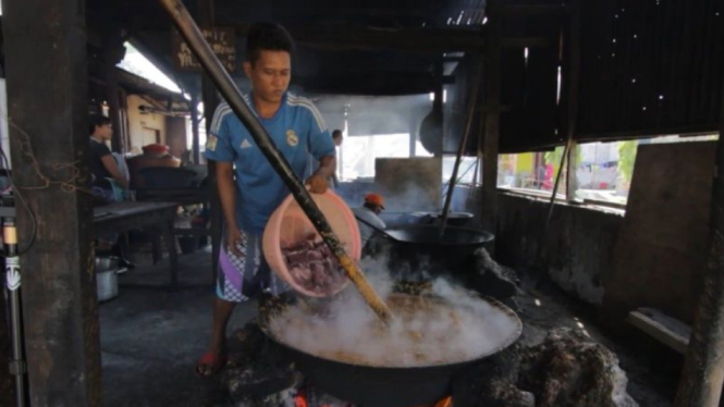 Seorang pekerja sedang membuat rendang di Sumatera Barat.