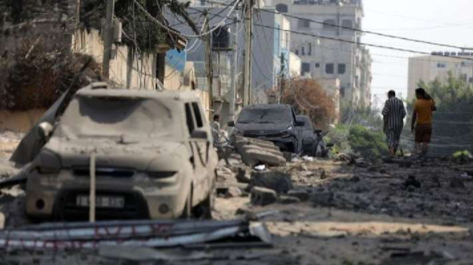 Beberapa warga Palestina berjalan di antara reruntuhan sekolah UNRWA di Kota Gaza, yang hancur semalam akibat serangan udara Israel pada 8 Oktober 2023.